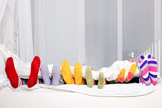 Colourful socks on family in bed