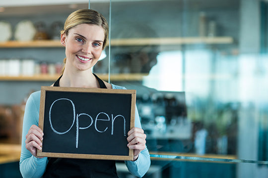 store clerk holding open sign