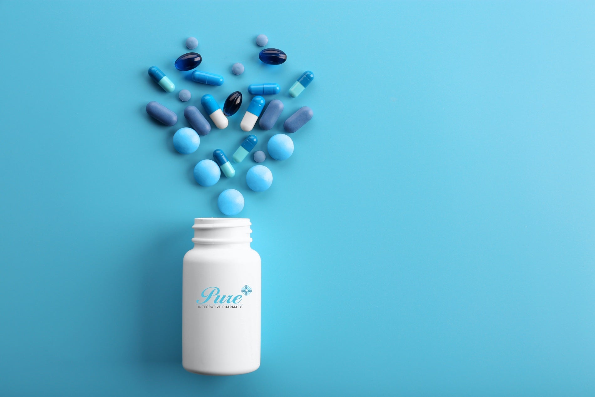 Pills laid out in a heart shape above a Pure-branded bottle on a blue background